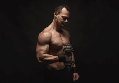Dumbbell aidatı çıplak kas vücut ile güçlü atletik erkek
