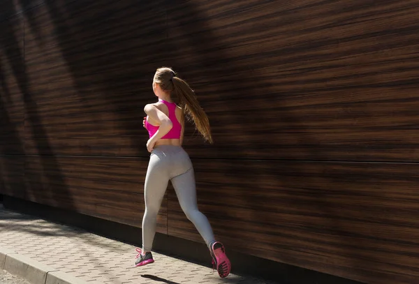 Young woman running in city copy space — Stock Photo, Image