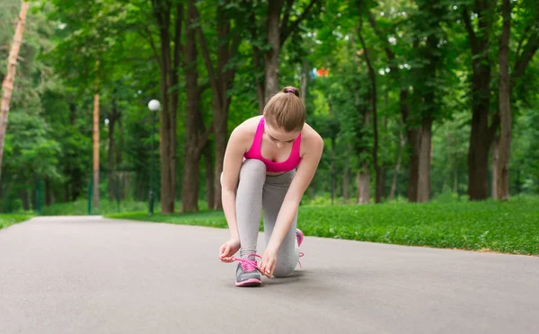 Mujer atando cordones zapatos antes de correr — Foto de Stock