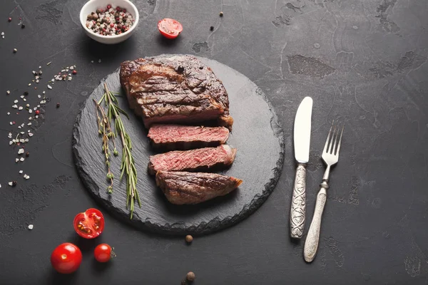 Filete de costilla y especias sobre fondo negro — Foto de Stock