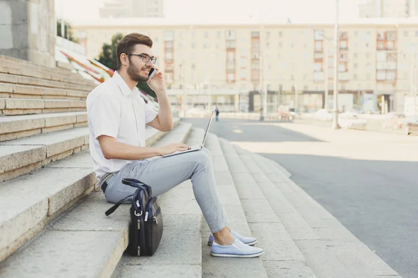 Joven hombre de negocios trabajando con el ordenador portátil al aire libre — Foto de Stock