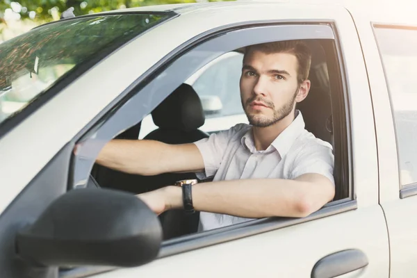 Porträt eines hübschen Kerls, der sein Auto fährt — Stockfoto