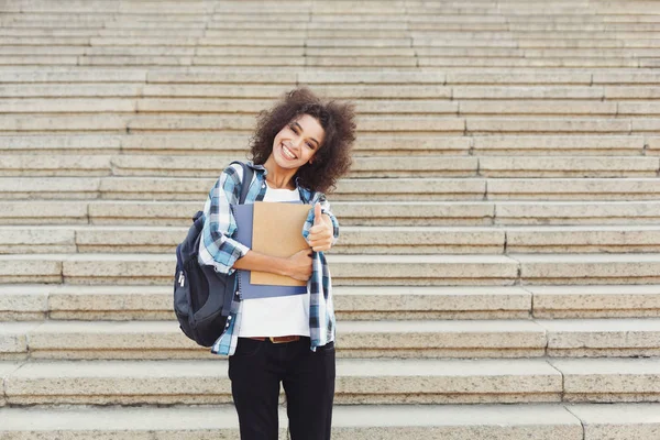 Student tjej med ryggsäck och arbetsböcker på betongtrappa bakgrund — Stockfoto