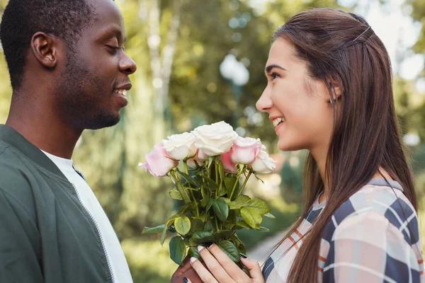 Człowiek daje się kwiaty o jego piękna dziewczyna — Zdjęcie stockowe