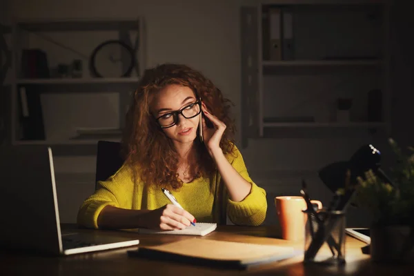 Serious woman at work talking on phone