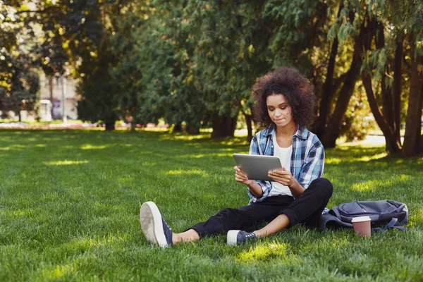 Mujer pensativa joven usando teléfono inteligente en el parque — Foto de Stock