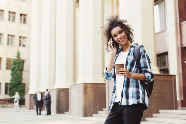 Studentjente med ryggsekk og mobil på universitetsbyggende bakgrunn – stockfoto