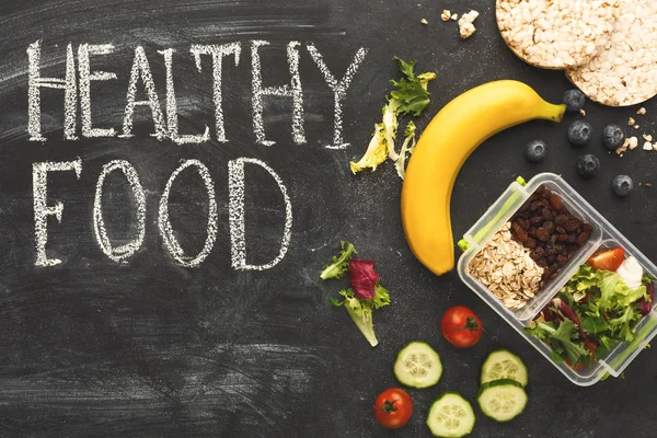 Lunch boxes filled with healthy food on black board — Stock Photo, Image