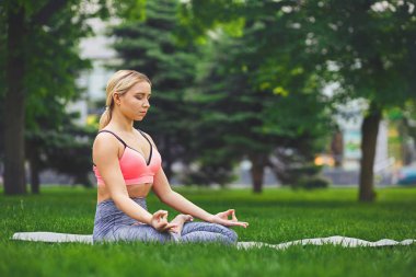 Genç kadın açık havada, sakin ol meditasyon poz