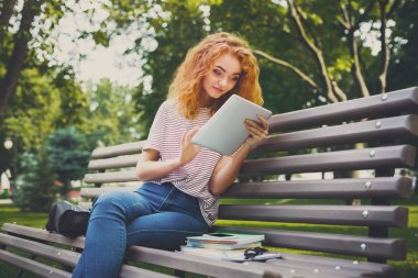 Kızıl saçlı kadın freelancer tablete açık havada sohbet