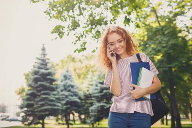 Parkta telefonda konuşurken genç Kızıl saçlı kız