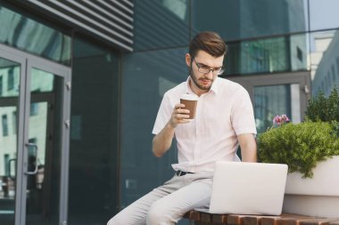 Genç işadamı dizüstü bilgisayar açık havada ile çalışma