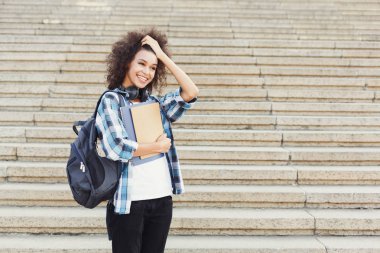 Sırt çantası ve çalışma kitapları, somut adımlar arka plan ile öğrenci kız