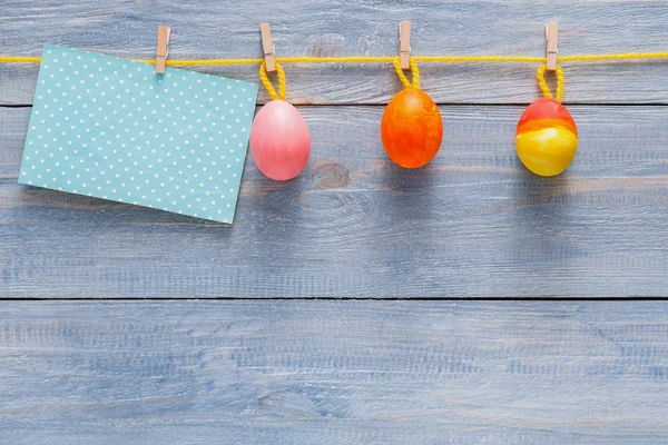 Carte de Pâques colorée et guirlande sur fond bois — Photo