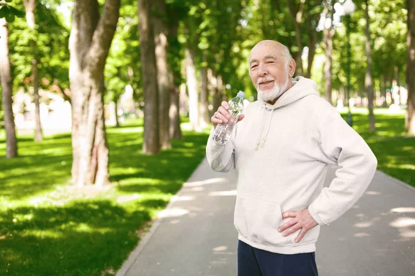 Senior man har paus, dricksvatten — Stockfoto