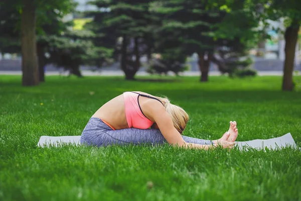 Kadın eğitim yoga diz poz için oturmuş kafasında.