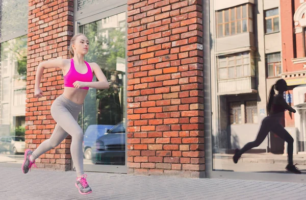 Young woman running in city copy space — Stock Photo, Image