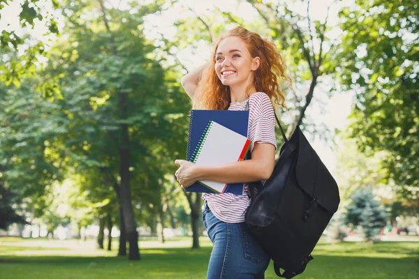 Junge rothaarige Studentin geht im Park spazieren — Stockfoto