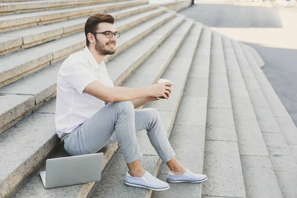 Joven hombre de negocios descansando con café al aire libre — Foto de Stock