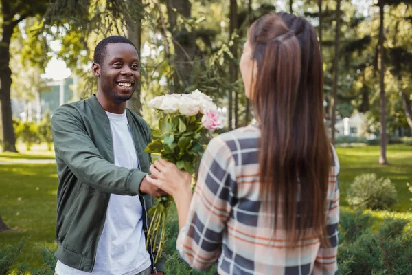 Man ger blommor för sin vackra flickvän — Stockfoto