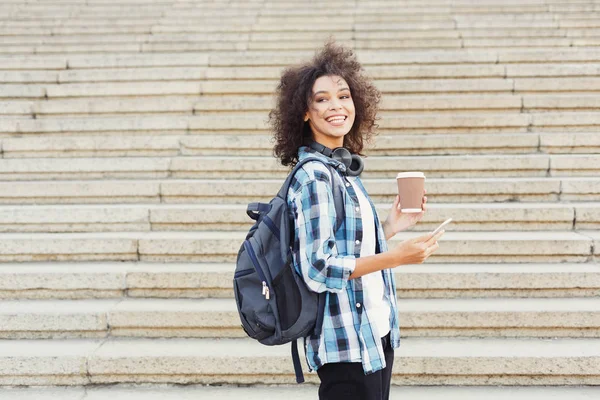 Estudiante chica con mochila y móvil en los pasos concretos de fondo — Foto de Stock