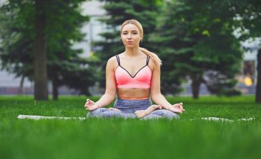 Genç kadın açık havada, sakin ol meditasyon poz