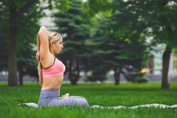 Woman training yoga in cow head pose — Stock Photo, Image