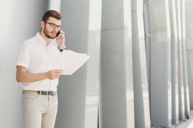 Genç işadamı açık havada belgelerle çalışma