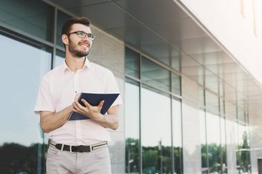 Genç işadamı açık havada belgelerle çalışma
