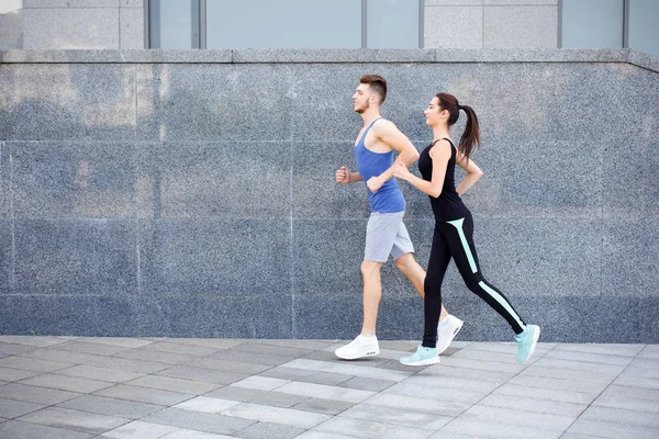 Junge Frau und Mann joggen in der City — Stockfoto