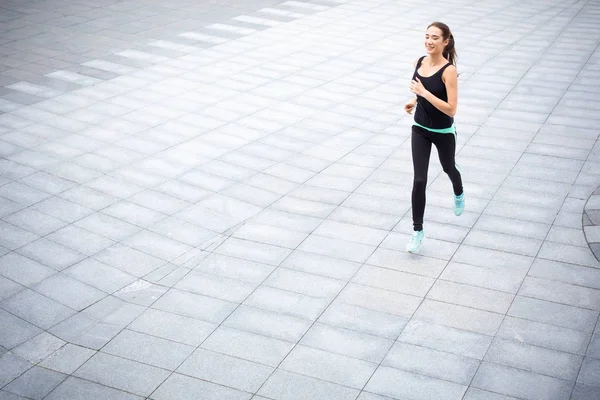 Mujer joven corriendo en el espacio de copia de la ciudad — Foto de Stock