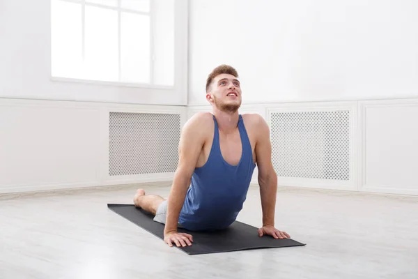 Hombre entrenando yoga en pose cobra, copiar espacio — Foto de Stock