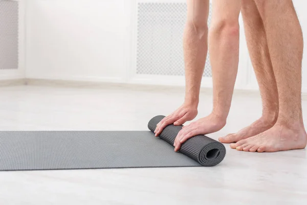 Mann rollt nach Yoga-Kurs die Matte — Stockfoto