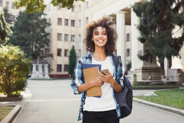 Student tjej med ryggsäck och mobil på Universitetshuset bakgrund — Stockfoto