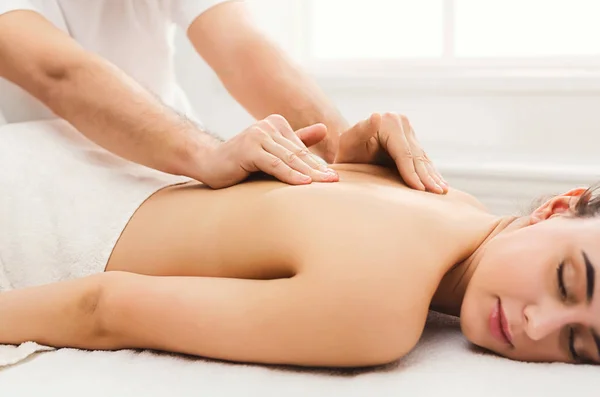 Fechar as mãos massagear ombros femininos e costas — Fotografia de Stock