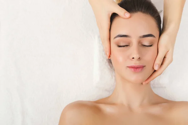 Mujer recibiendo masaje facial profesional en el salón de spa —  Fotos de Stock