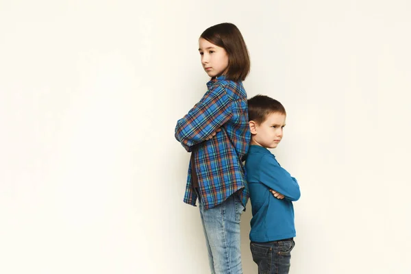 Pequeña niña y su hermano de pie espalda con espalda — Foto de Stock