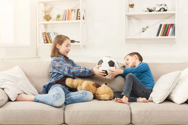 Bratr a sestra doma drží fotbalový míč — Stock fotografie
