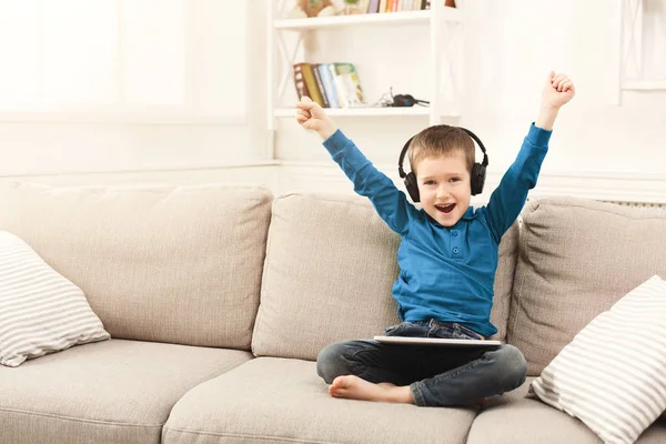 Bambino che usa tablet digitale sul divano di casa — Foto Stock