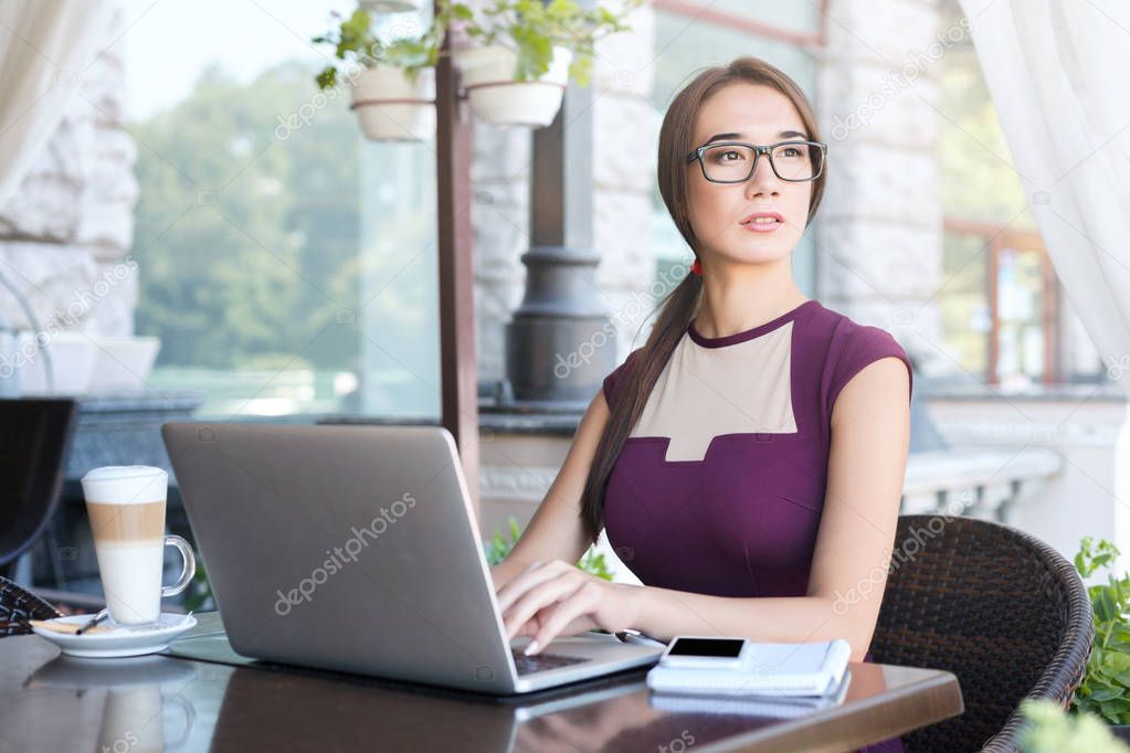 Young businesswoman working with laptop in cafe