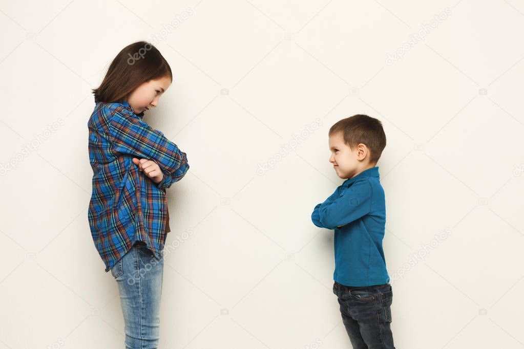 Small girl and her brother standing face to face