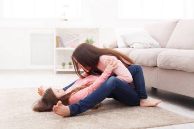 Yatak odasında oturma sevimli küçük kızı annesiyle.
