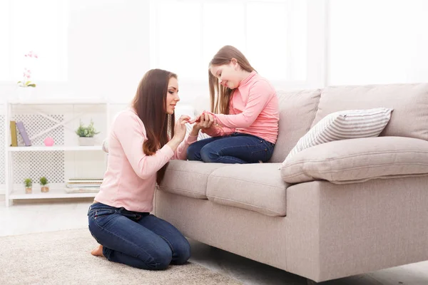 Moeder met haar schattige kleine dochter zit in de slaapkamer. — Stockfoto