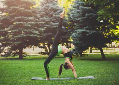 Genç kadın yapma tekerlek poz açık havada