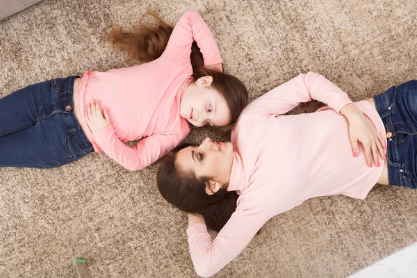 Yerde yatarken şirin küçük kızı annesiyle — Stok fotoğraf