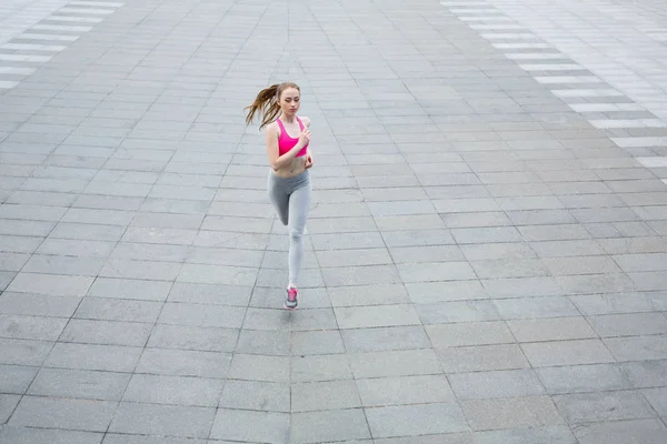 Young woman running in city copy space — Stock Photo, Image