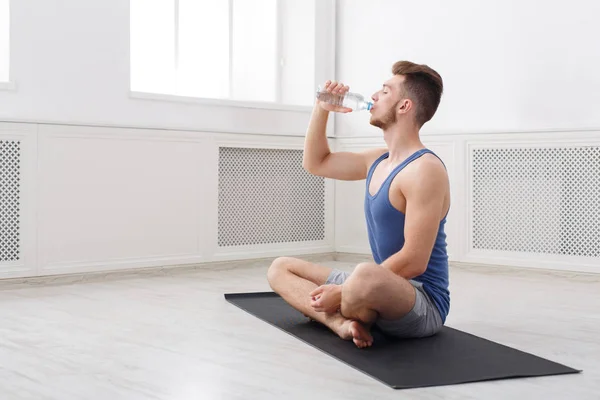 Man dricksvatten på gym på vit bakgrund — Stockfoto