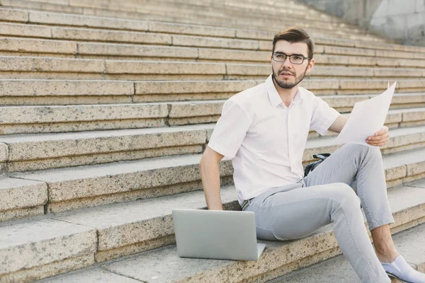 Empresário pensativo trabalhando com laptop ao ar livre — Fotografia de Stock