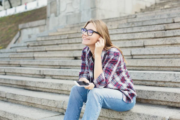 Fiatal lány Egyetem lépcsőn zene hallgatása — Stock Fotó