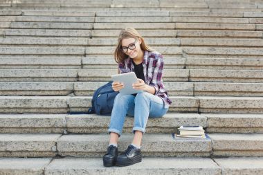 Mutlu genç kadın dijital tablet açık havada kullanma